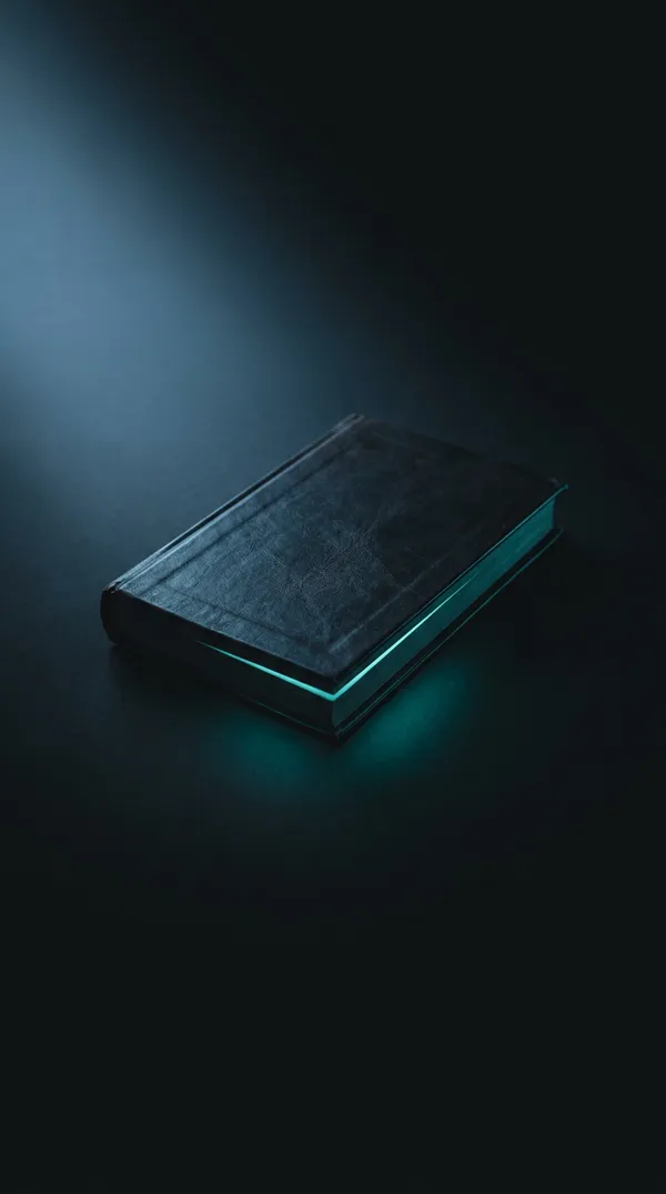 Closed book with teal light leaking from its pages